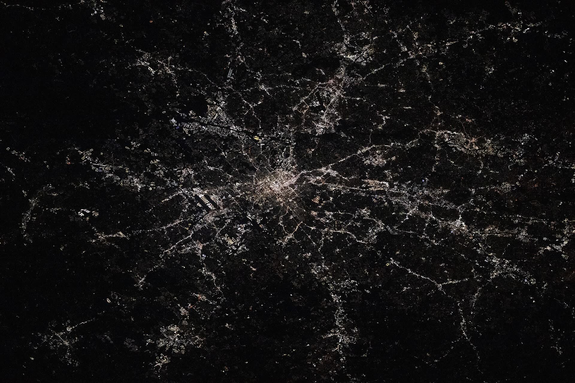 Atlanta’s street grid at night, with the long lit runways of its airport to the south