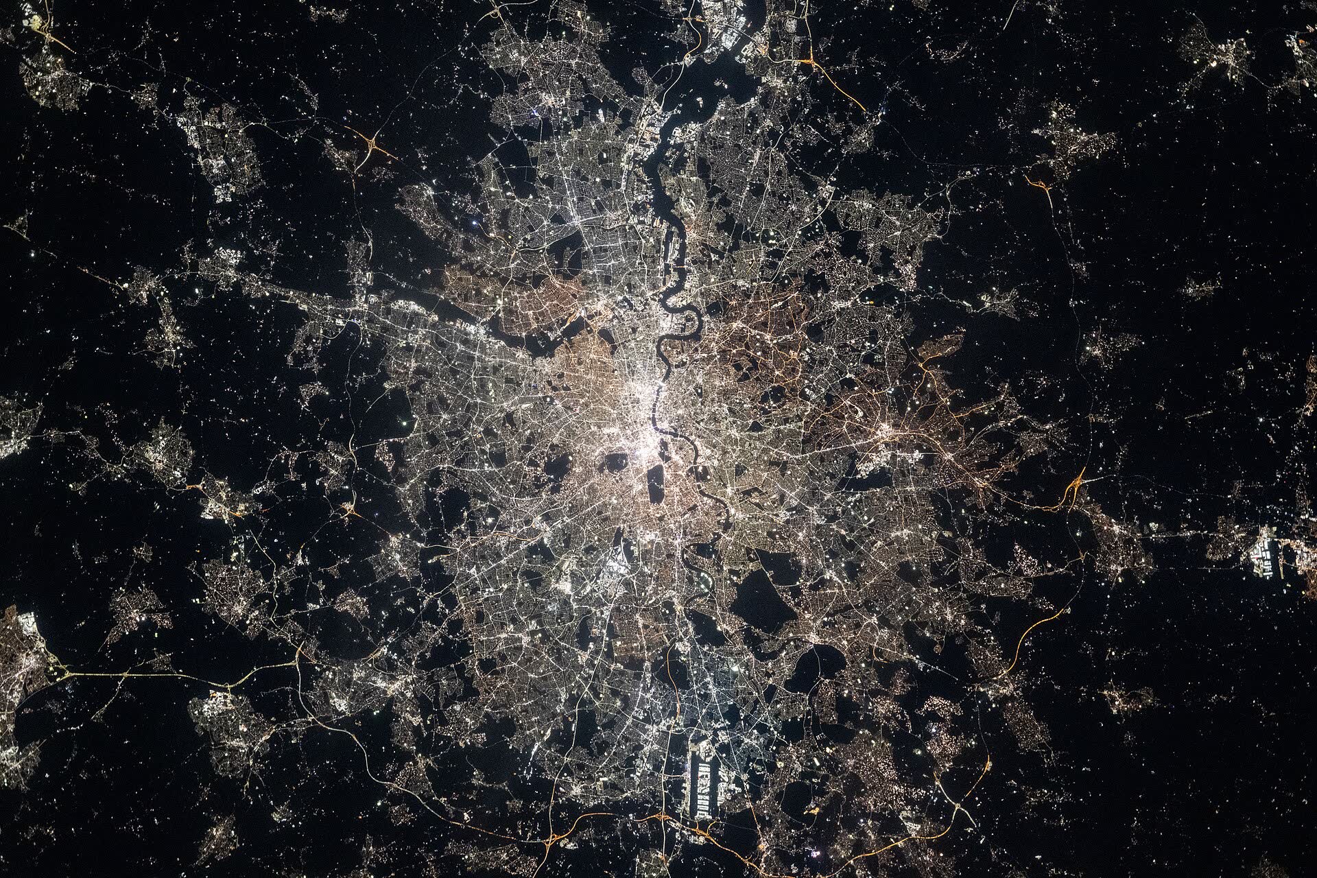 London at night, a white web of streets split by the dark line of the Thames